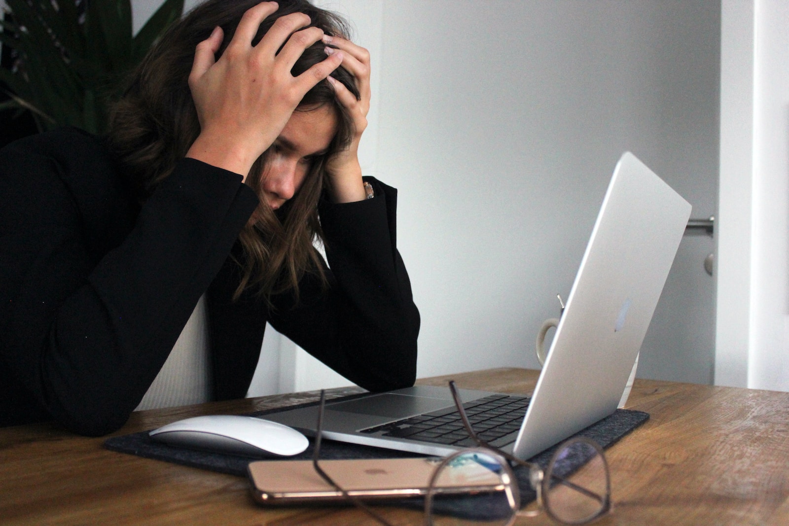 woman in black long sleeve shirt covering her face with her hands